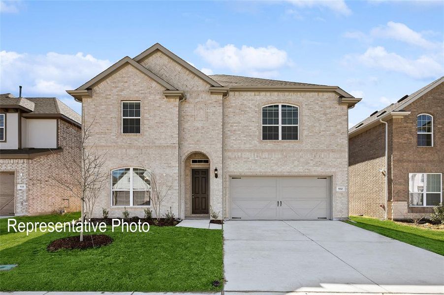 View of front facade featuring a garage and a front lawn