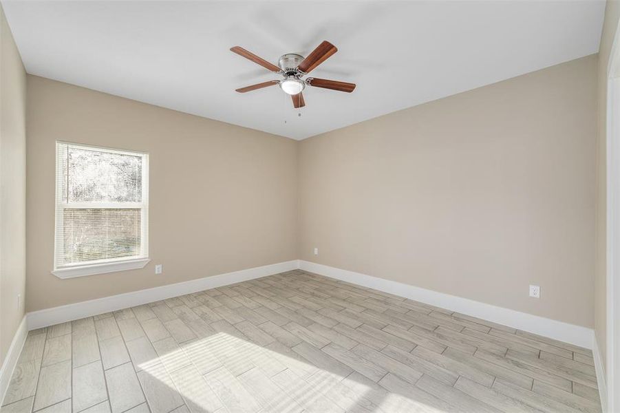 Unfurnished room featuring ceiling fan and light wood-type flooring