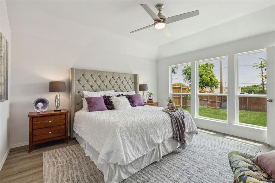 Bedroom with multiple windows, ceiling fan, and wood-type flooring