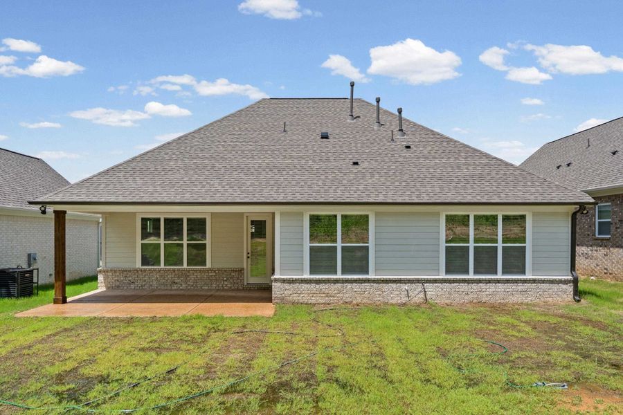 Rear exterior featuring a covered patio with a stained wood beam, multiple windows, and a stone veneer foundation Rear exterior featuring a covered patio with a stained wood beam, multiple windows, and a stone veneer foundation