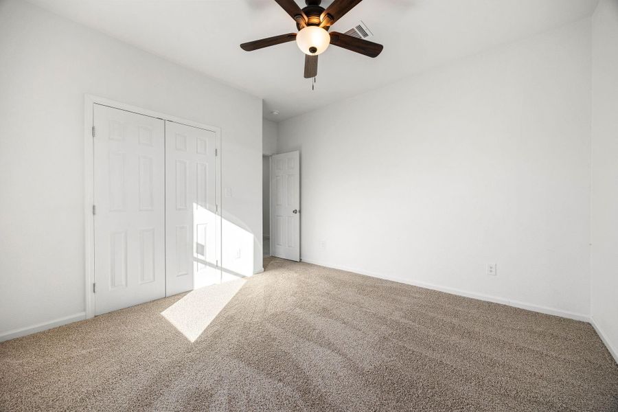 Bright and welcoming fourth bedroom with plush carpet, generous closet, and a chic ceiling fan. Bright and welcoming fourth bedroom with plush carpet, generous closet, and a chic ceiling fan.