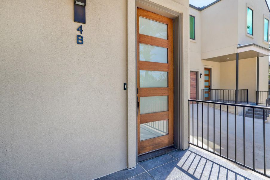 View of exterior entry with stucco siding and a balcony