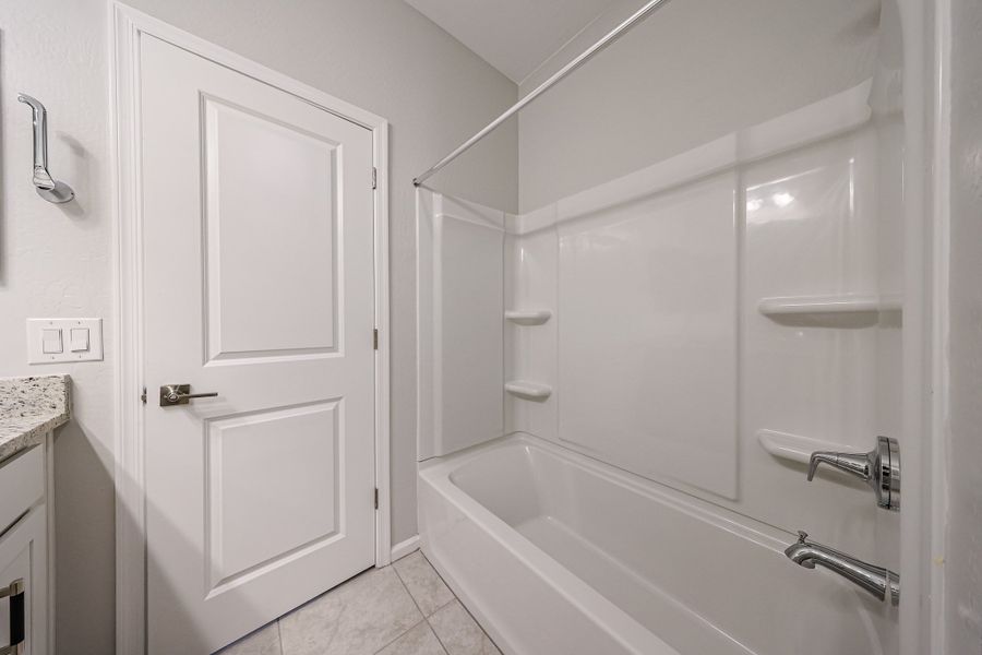 A bathroom with a shower unit and a bathtub.