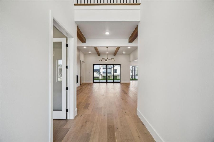 Hallway featuring a chandelier, light wood finished floors, beam ceiling, and recessed lighting Hallway featuring a chandelier, light wood finished floors, beam ceiling, and recessed lighting