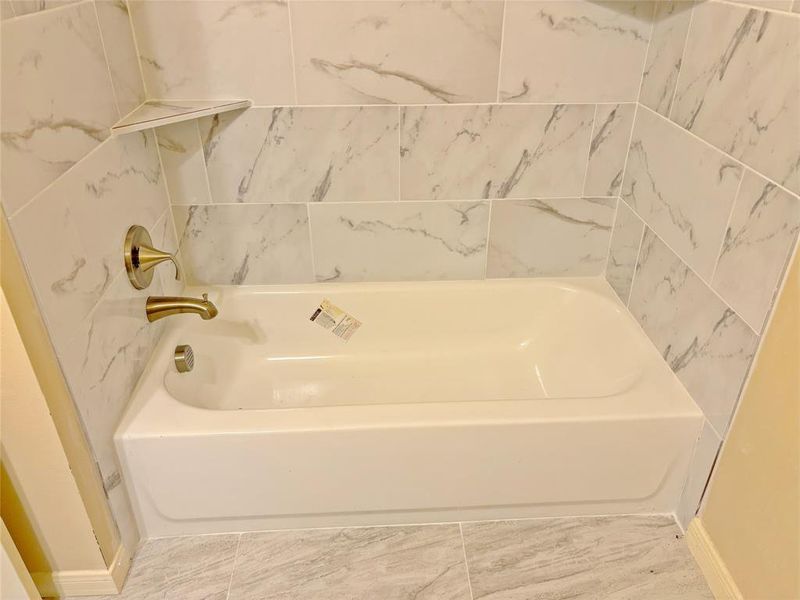 Bathroom with a tub to relax in and tile patterned flooring