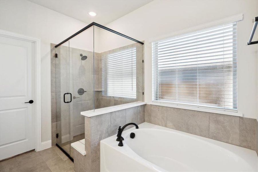 Full bath featuring a garden tub, a stall shower, and tile patterned flooring
