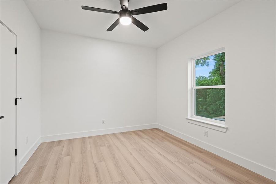 Spare room with light wood finished floors, baseboards, and ceiling fan Spare room with light wood finished floors, baseboards, and ceiling fan