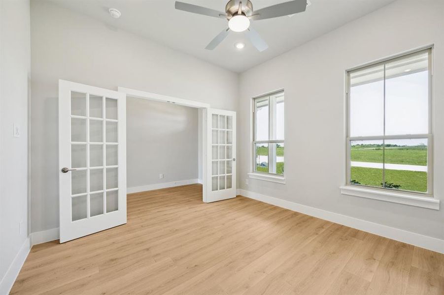 Unfurnished room with light wood-type flooring, a ceiling fan, french doors, and recessed lighting