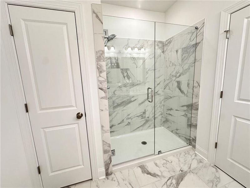 Upgraded marble shower pans with 12x24 tile surround with frameless shower door *photos are from the Magnolia model at different home site*