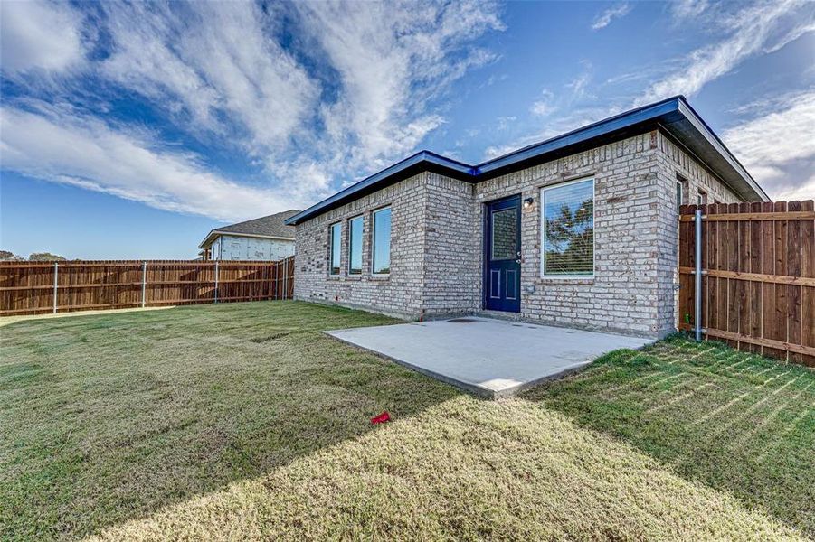 Rear view of house with a yard and a patio area