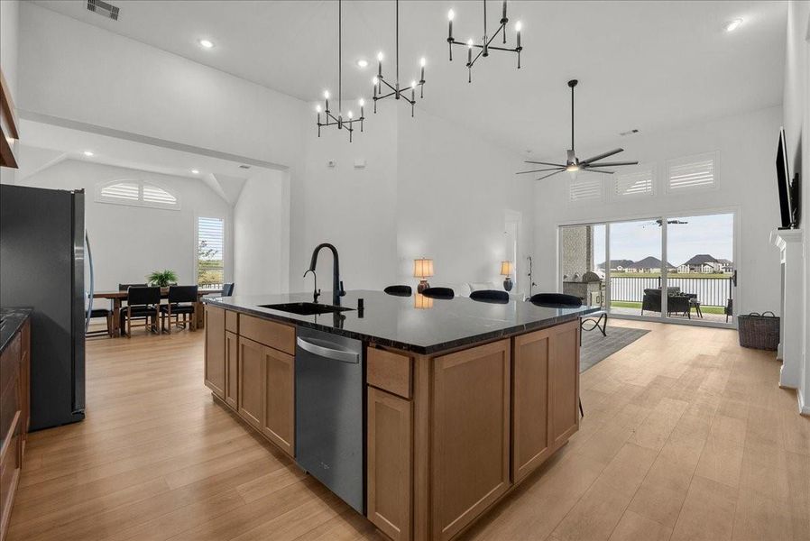 Chef’s kitchen overlooks the spacious living area and boasts double ovens, pot filler, granite countertops, designer backsplash, upgraded cabinetry, stainless steel appliances, stylish finishes, and oversized island seating.