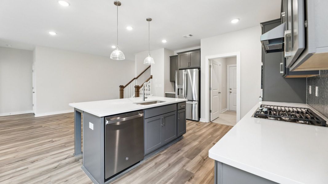 Kitchen with quarts countertops, pendant lighting, and hard surface flooring