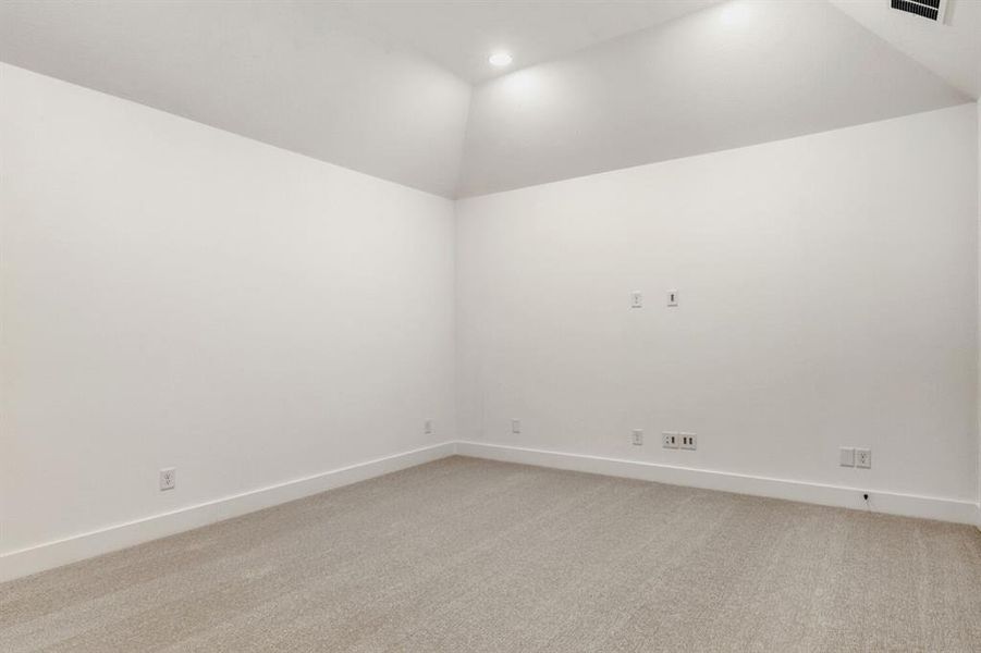 Empty room with vaulted ceiling, light carpet, and recessed lighting