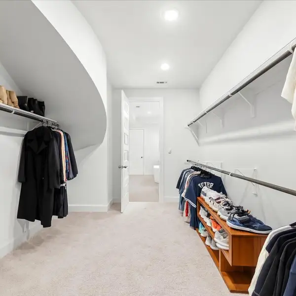 Shop until you drop! This deep walk-in closet offers ample space for hanging clothes, shoes, bags and more. As a super bonus, this closet also attaches to the utility room. This photo has been virtually staged.