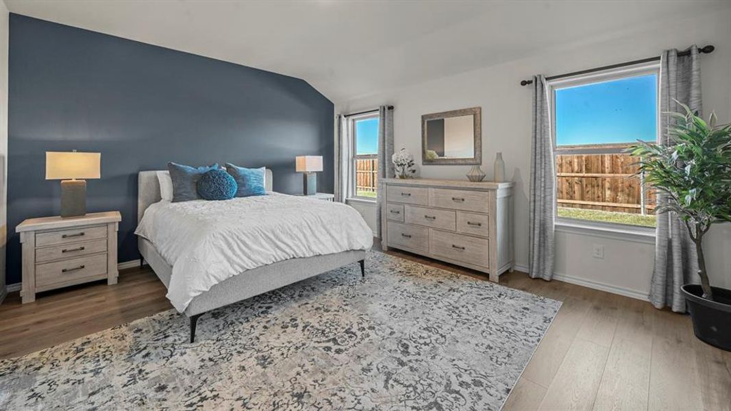 Bedroom featuring light wood finished floors and lofted ceiling