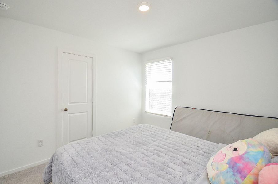 This floor plan features an open layout with a family room, dining room, and kitchen connected. The owner's suite includes a walk-in closet and bath. There's also a powder room, laundry area, and a spacious two-car garage. The entrance has a welcoming porch.