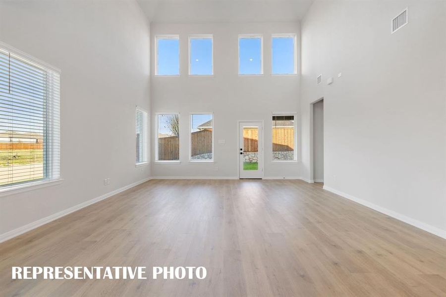 Featuring a dual stacked wall of windows, this wonderful family room is flooded with natural light.  REPRESENTATIVE PHOTO
