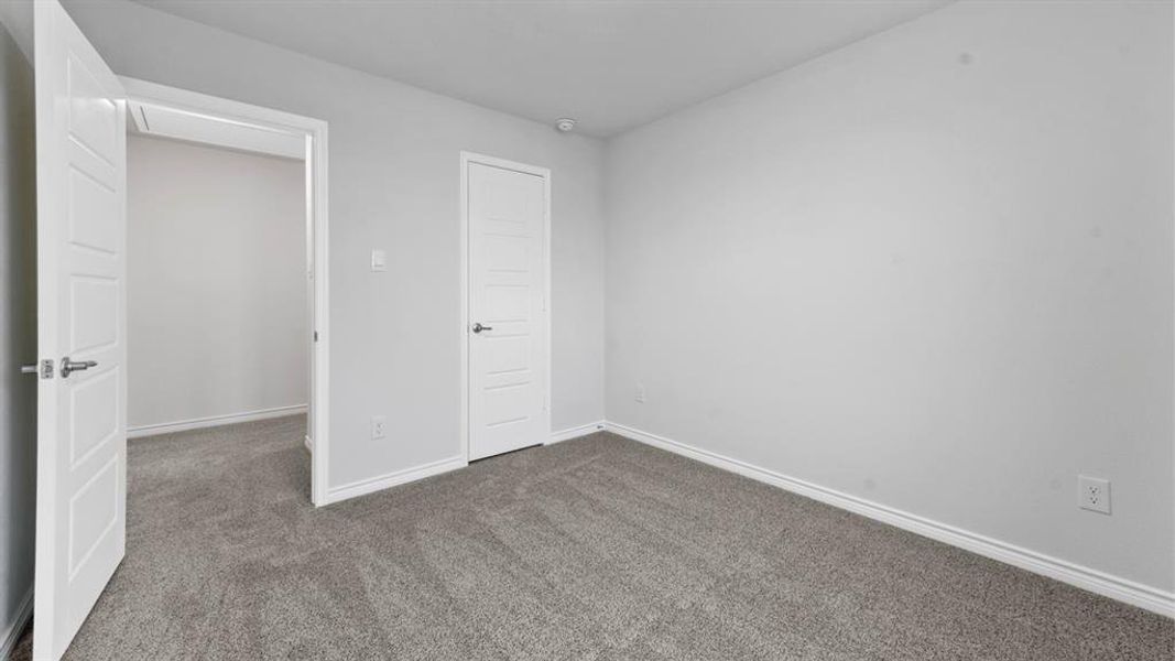 Neutral gray carpeting complemented by crisp white baseboards and wall color