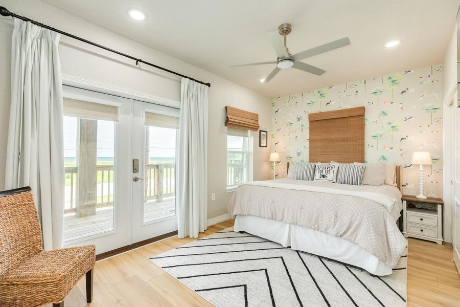 Spacious primary bedroom features direct balcony access, abundant natural light, and coastal views, providing a peaceful retreat.