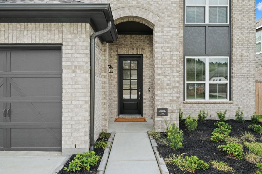 Beautifully designed curb appeal and covered patio provide a welcoming entrance.