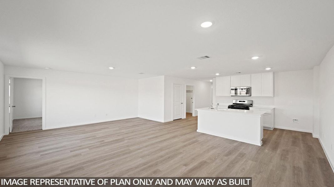 Kitchen with open floor plan, light wood-style flooring, recessed lighting, an island with sink, and white cabinets