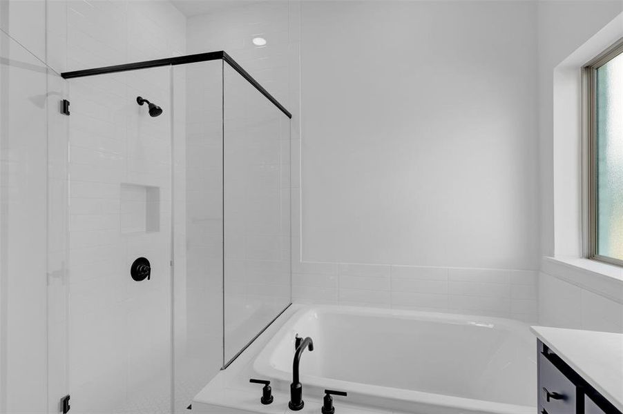 Bathroom featuring a garden tub, vanity, and a stall shower