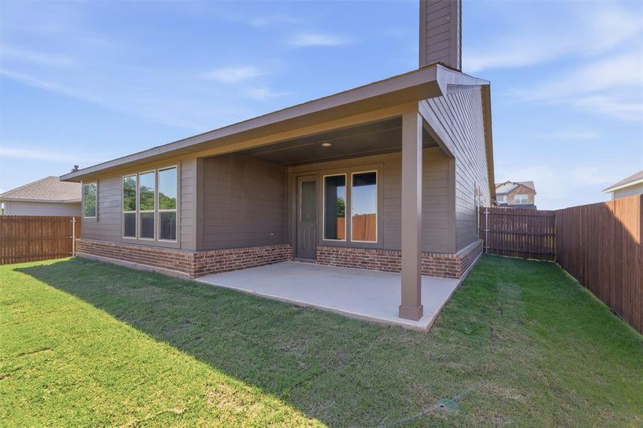 Back of property featuring brick siding, a patio, and a fenced backyard