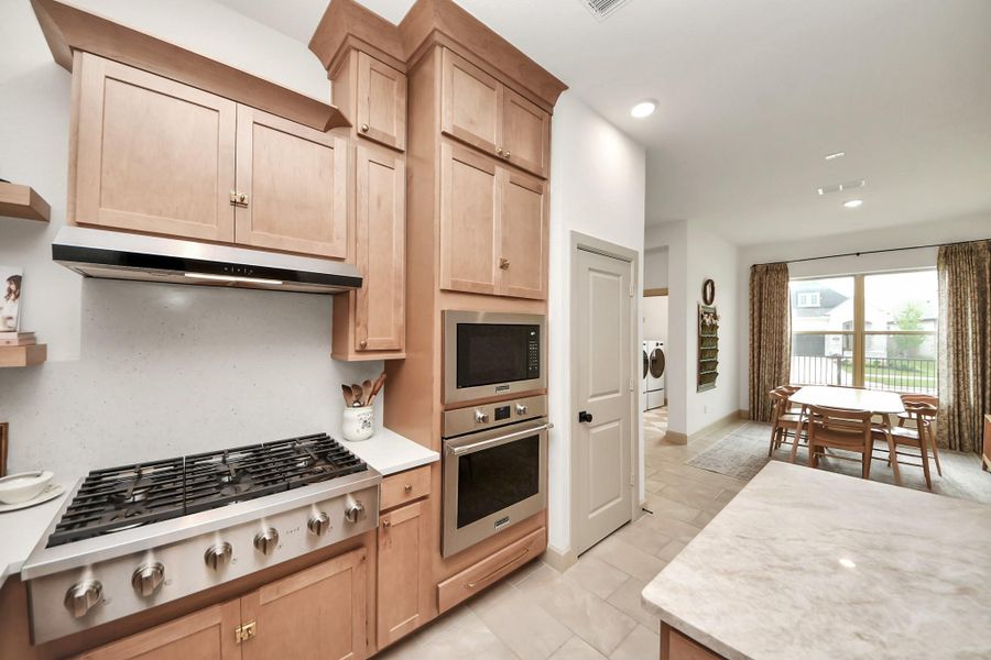 This kitchen boasts a Chef's Cafe cooktop, complemented by abundant cabinet space, perfect for culinary enthusiasts and storage seekers alike.