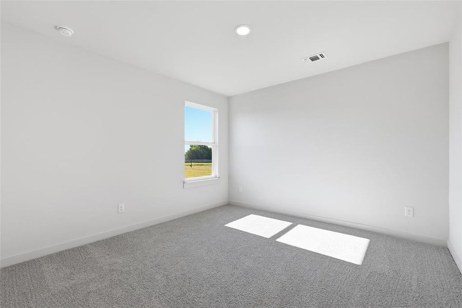 Bright interior space featuring a window with exterior scenery, recessed lighting, and grey carpeting