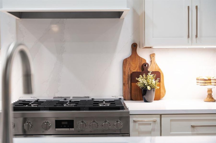 Stainless steel appliances including a gas range, built-in oven, and microwave add the finishing touches to this gourmet space