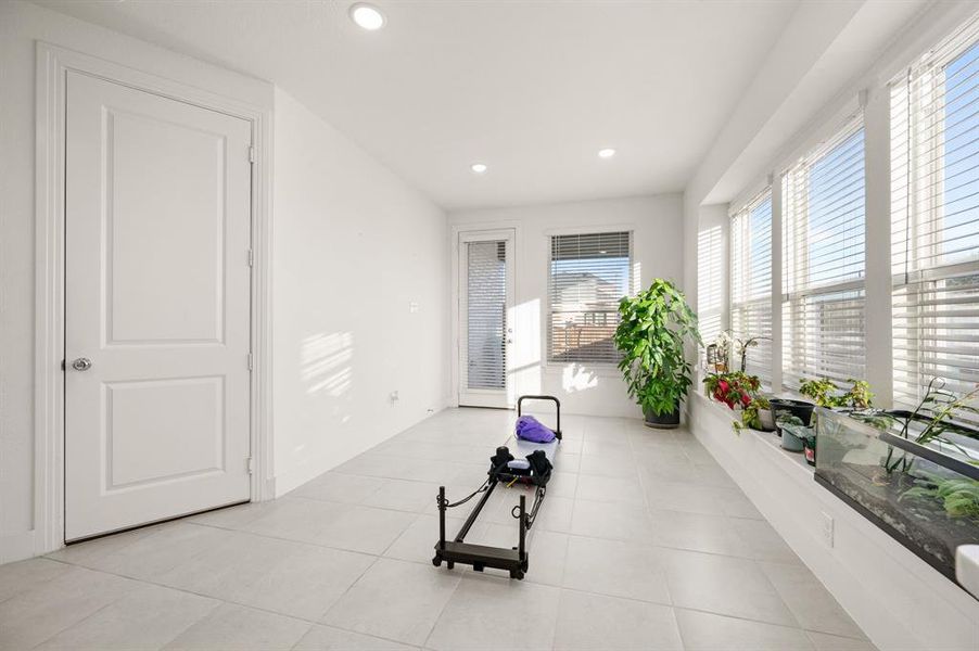 Exercise room with recessed lighting and light tile patterned flooring