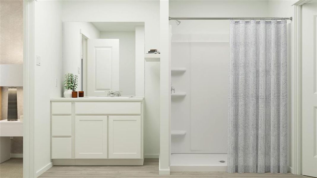 Full bath with a stall shower, vanity, and light wood-type flooring