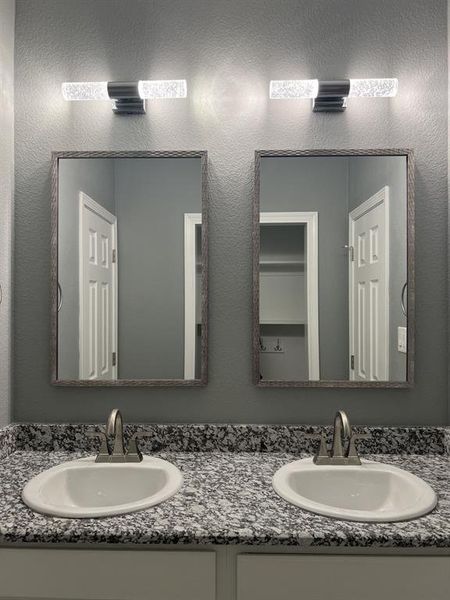 Bathroom with double vanity and a textured wall Bathroom with double vanity and a textured wall