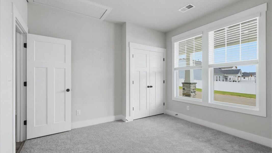 Accomplished design shines in this carpeted bedroom with a functional walk-in closet by DRB Homes