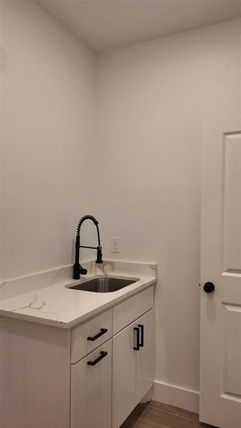 Washroom featuring a sink and dark wood finished floors Washroom featuring a sink and dark wood finished floors