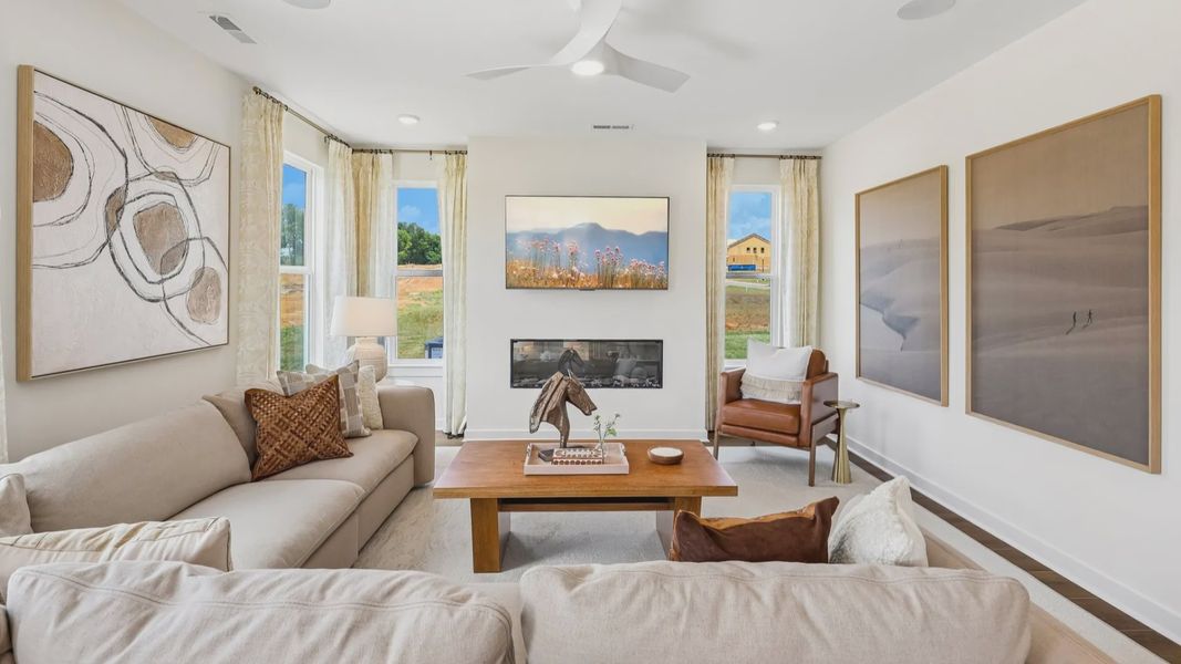 Gathering room with ceiling fan, windows, and fireplace