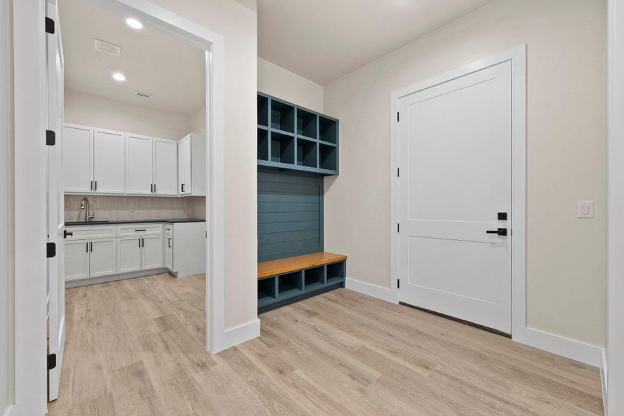 A versatile mudroom entry with built-in storage connects to a well-appointed utility room.