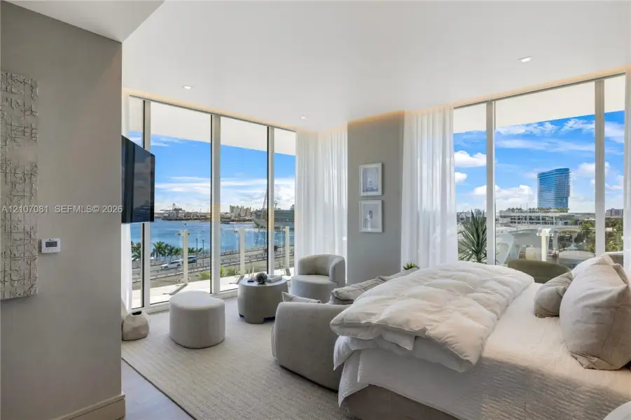 Floor-to-ceiling windows, neutral carpeting, recessed lighting, and a glass-paneled balcony Floor-to-ceiling windows, neutral carpeting, recessed lighting, and a glass-paneled balcony
