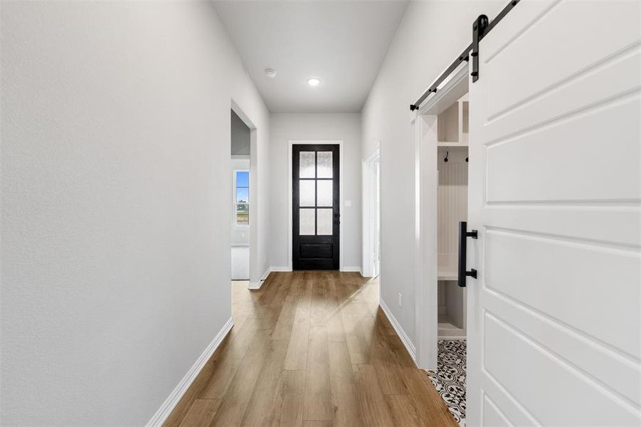 Entryway featuring a barn door, wood finished floors, and recessed lighting Entryway featuring a barn door, wood finished floors, and recessed lighting
