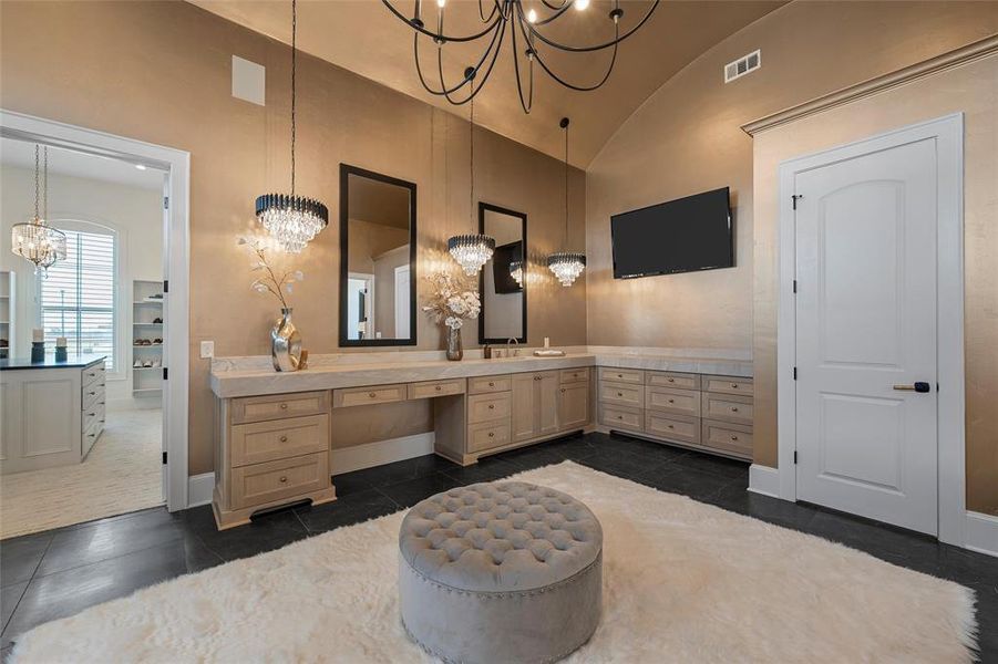 Bathroom featuring vanity, a chandelier, vaulted ceiling, and dark tile patterned floors