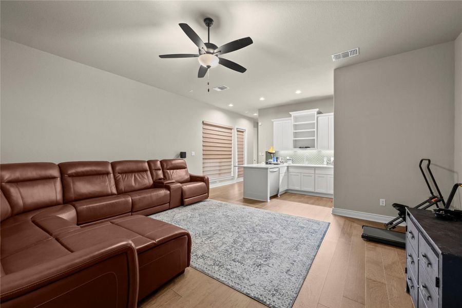 An open-concept living area boasts warm wood flooring and a refreshing kitchen nook. An open-concept living area boasts warm wood flooring and a refreshing kitchen nook.