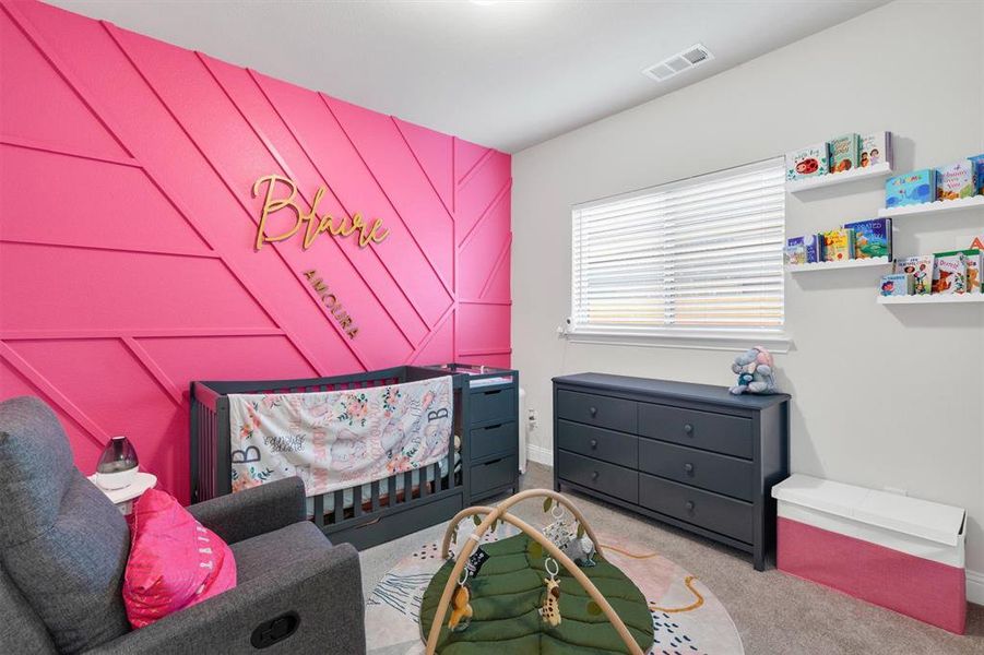 Feature wall with geometric paneling, carpeted flooring, window with horizontal blinds, built-in wall shelving