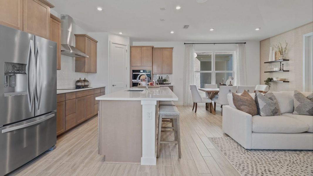 Open main floor kitchen, family room and cafe in a DRB Home Clementine model at the Trinity Place community.