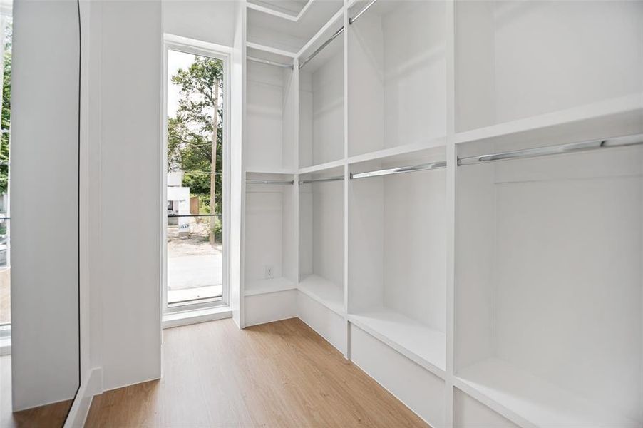 Built-in white custom closet system featuring multiple shelving units and chrome hanging rods