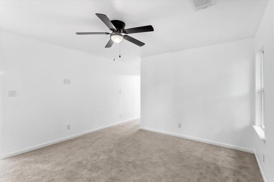 Master bedroom with ceiling fan and light carpet