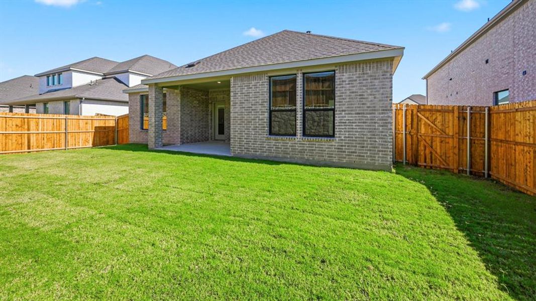 Back of house with brick siding, a patio, a fenced backyard, and a shingled roof Back of house with brick siding, a patio, a fenced backyard, and a shingled roof