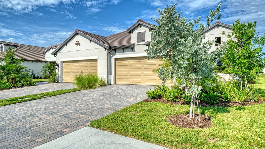 Front exterior of a new home in Vistera of Venice Real Estate and Homes for Sale in Venice, FL - Neal Communities, Nokomis, FL, highlighting curb appeal (Image 2).