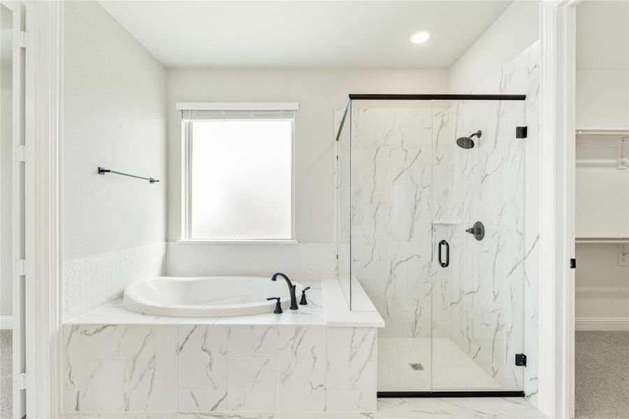 Master bathroom with marble soaking tub, glass walk-in shower, and black fixtures Master bathroom with marble soaking tub, glass walk-in shower, and black fixtures