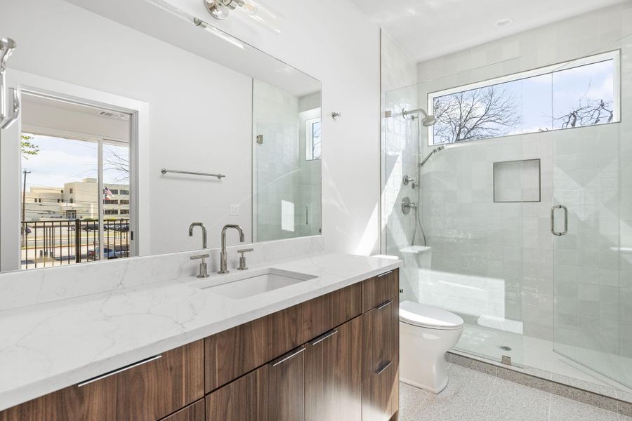 Full bath with vanity, toilet, and a stall shower