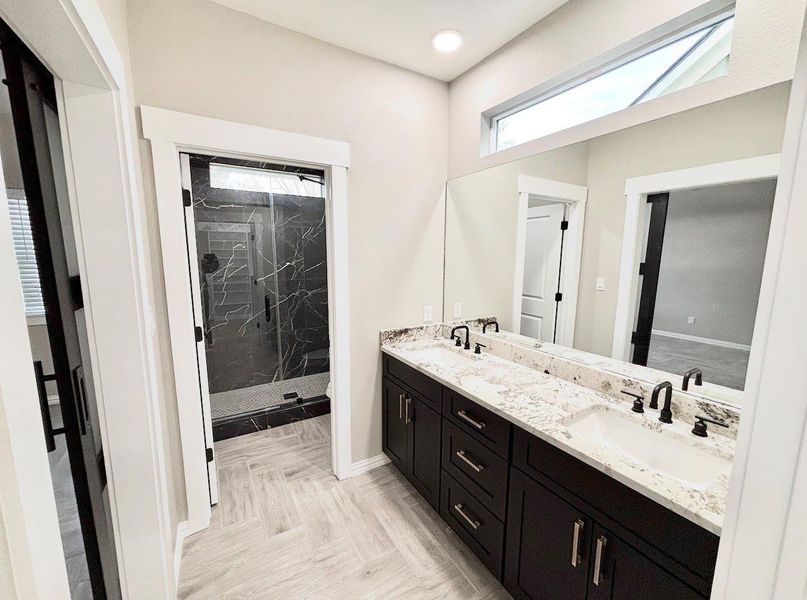 Primary bath with walk in shower, double sinks and quartzite counters.